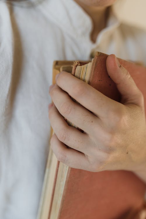 A Person Holding a Brown Book