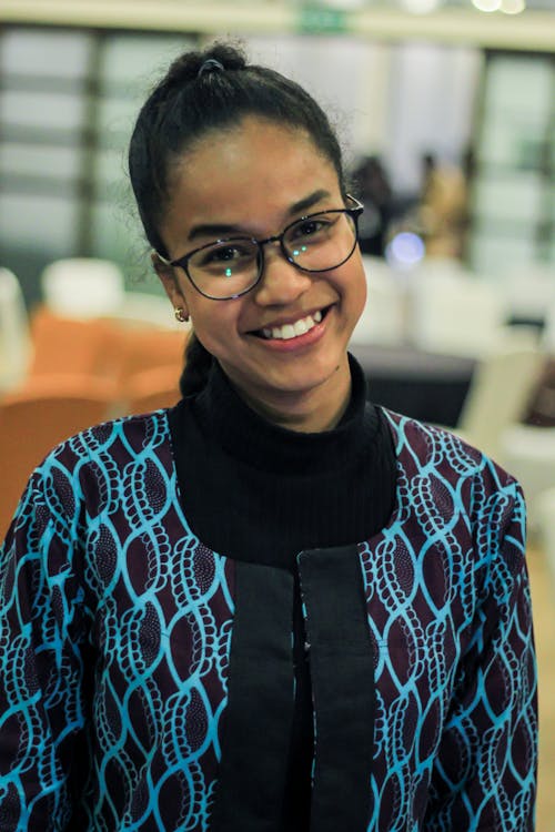 A Woman Smiling while Wearing Eyeglasses