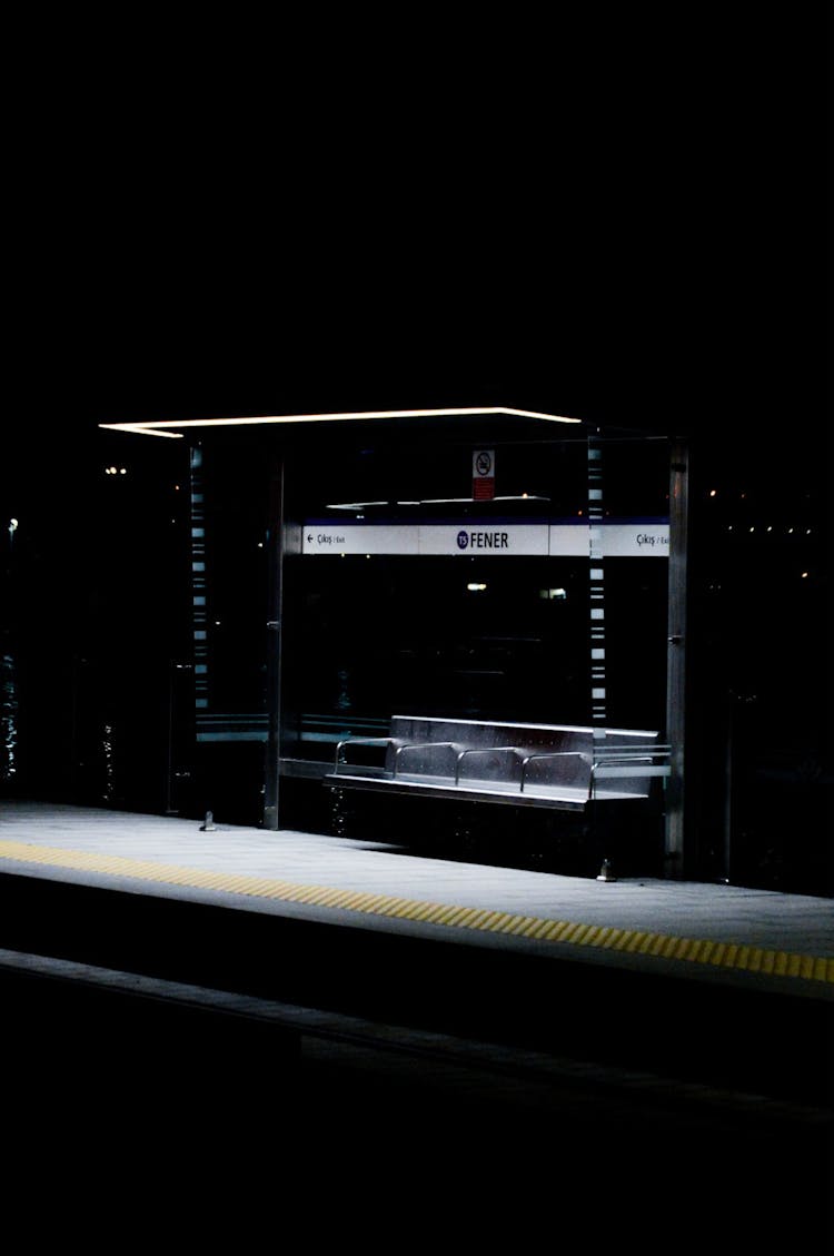 Modern Glass Bus Stop Illuminated With Light At Night