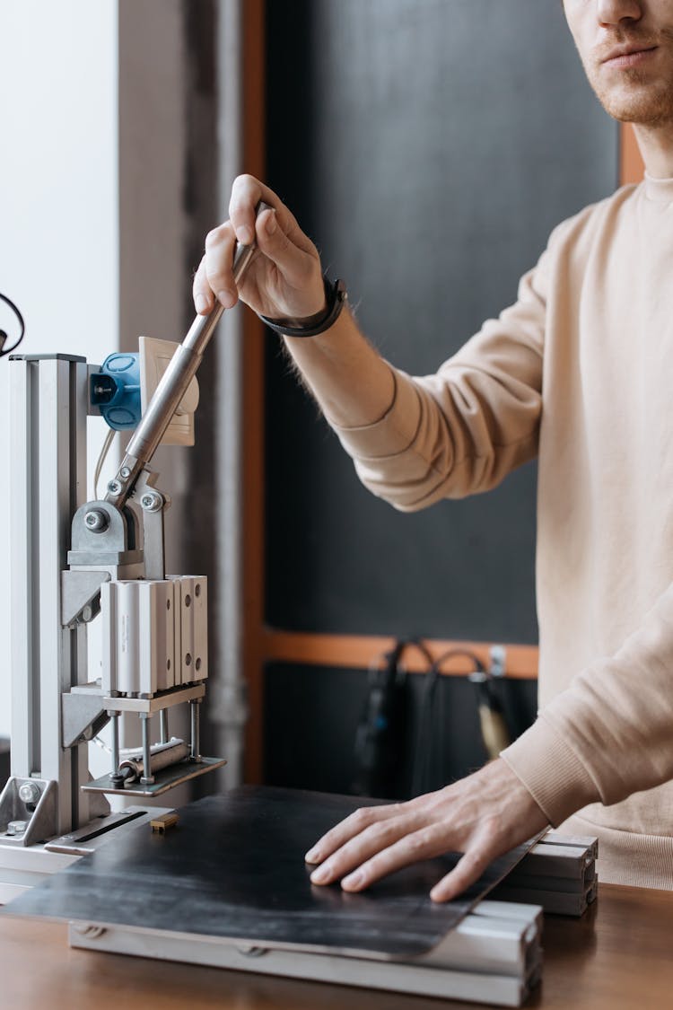 A Person Holding The Lever Of A Machine