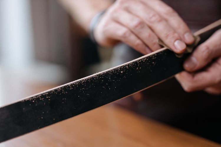 A Person Polishing A Wooden Slab With A Sand Paper