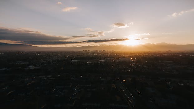 Dramatic aerial sunset view over San Jose showcasing urban skyline and golden skies.