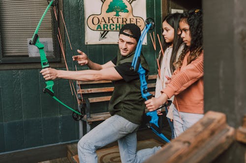 Free A Man Teaching Two Girls On Archery Stock Photo