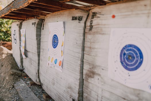 Archery targets lined up outdoors for practice, featuring colorful bullseyes.