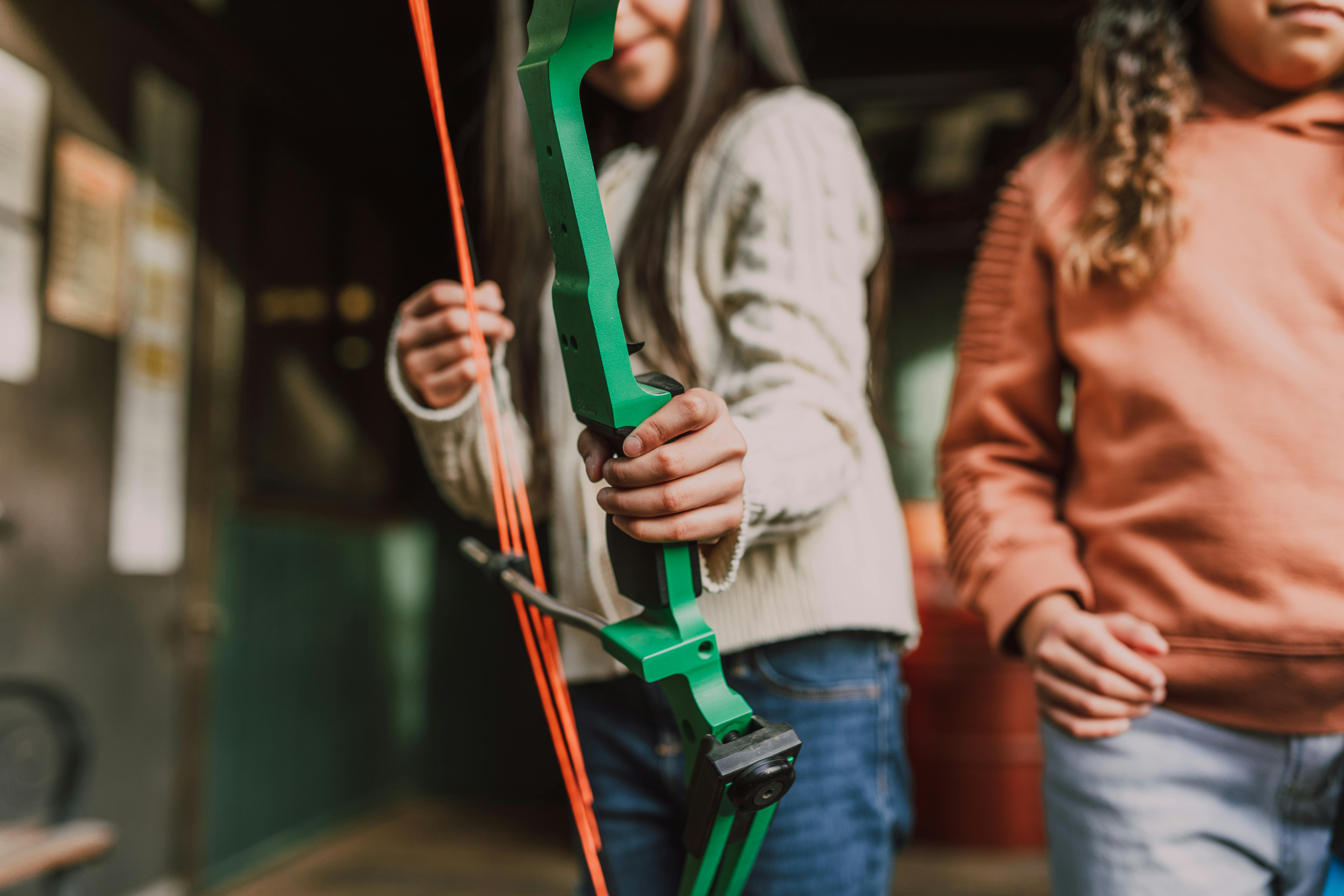 two girls holding an archery bow