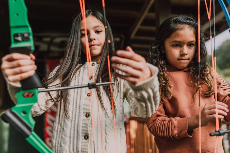 Two Girls Holding An Archery Bow