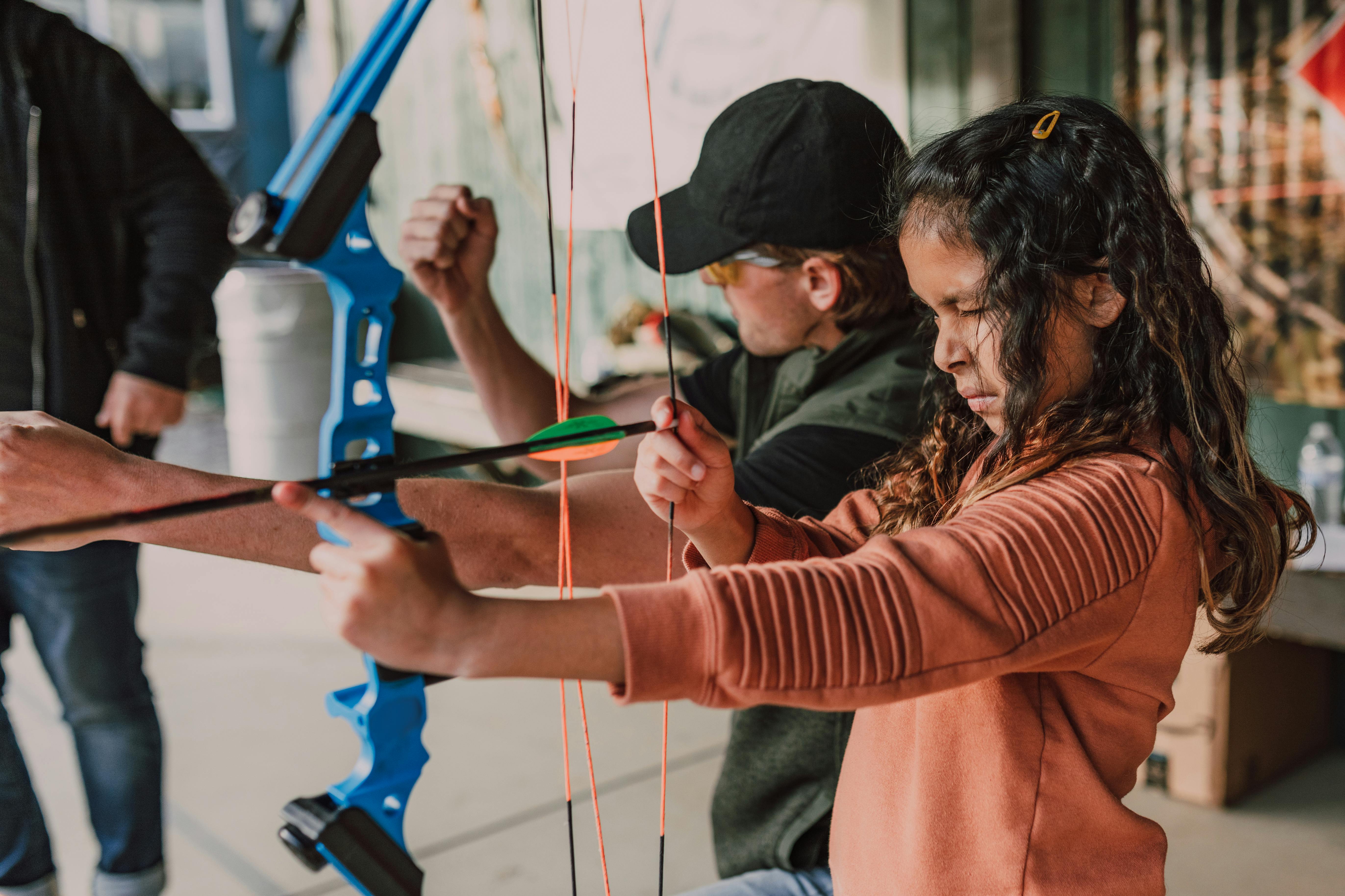 a girl holding an archery bow