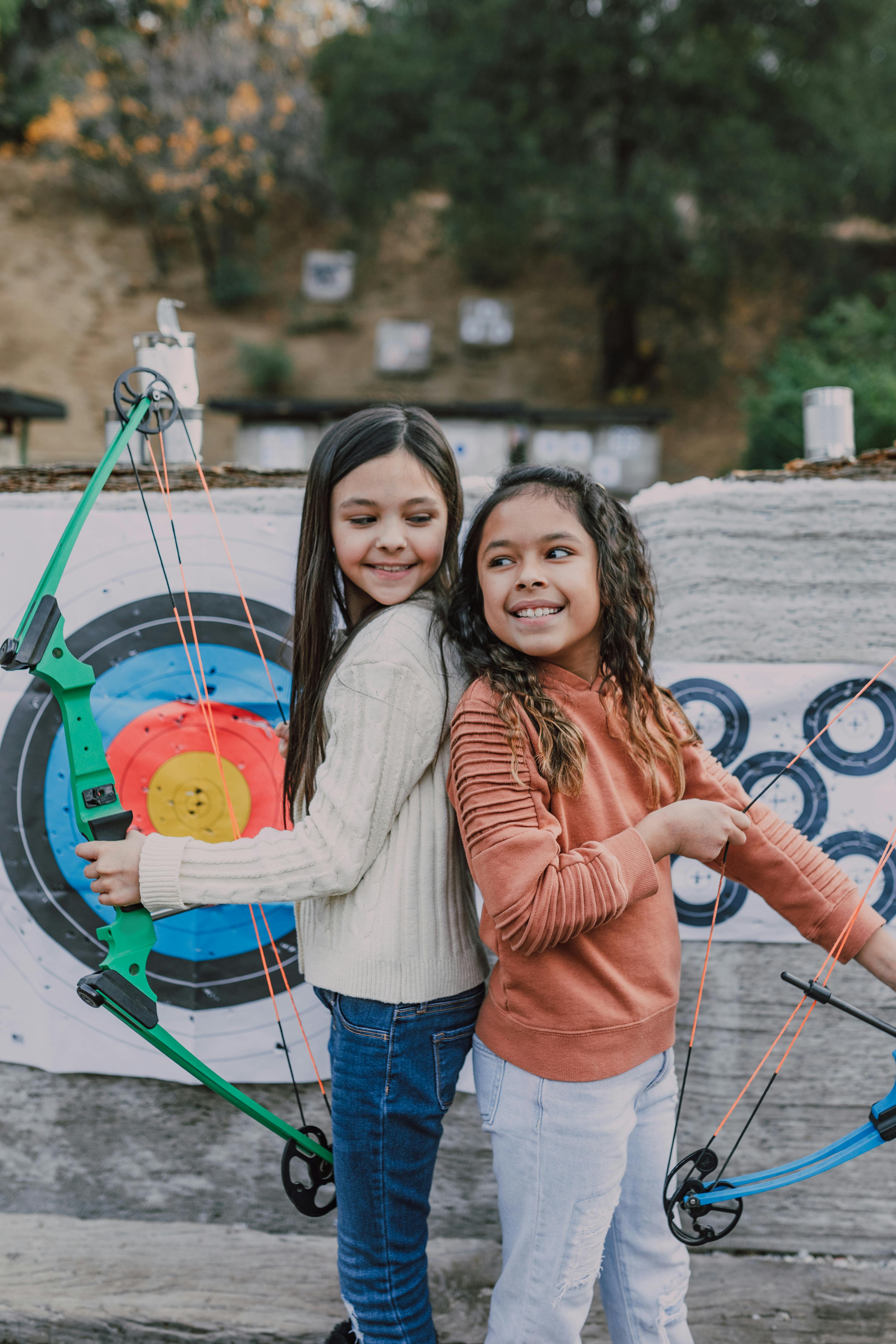 two girls holding an archery bow