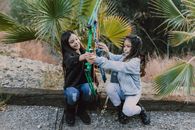 Two Girls Holding an Archery Bow while Sitting