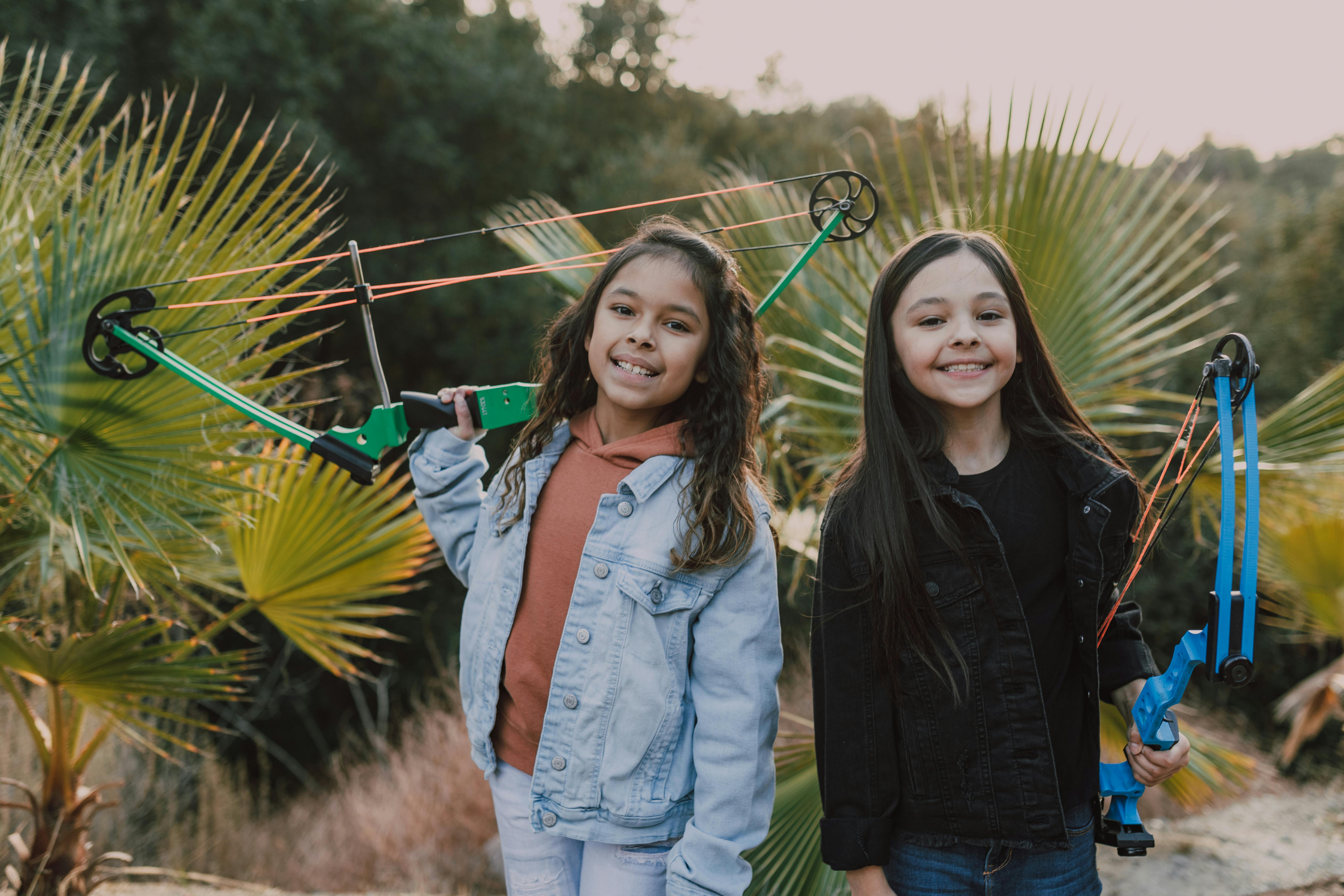 two girls holding an archery bow