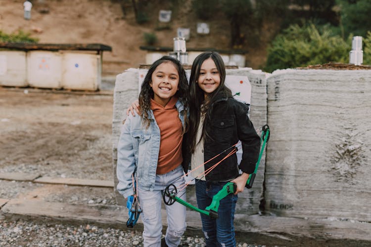 Two Girls Holding A Archeries