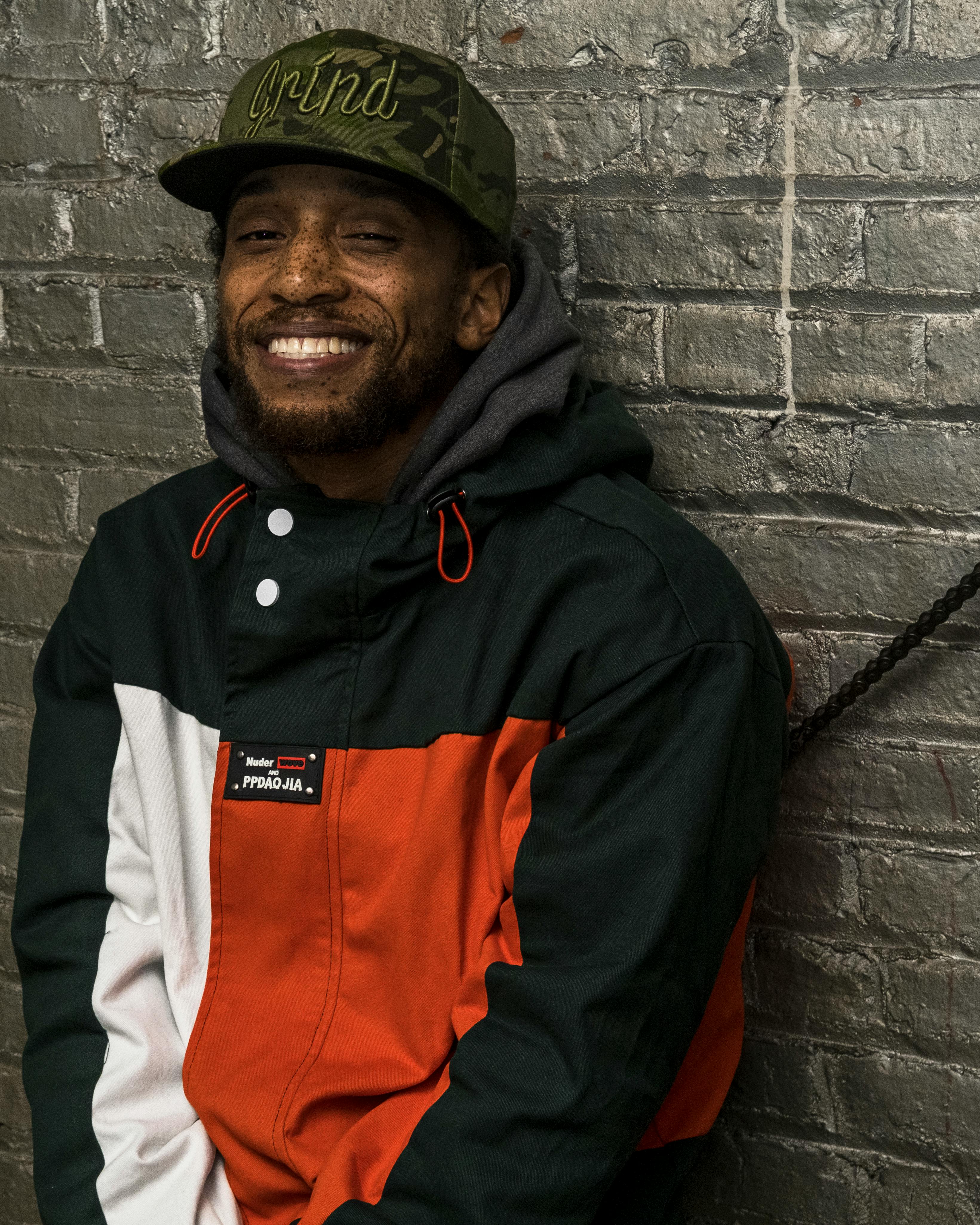 smiling man in jacket and cap