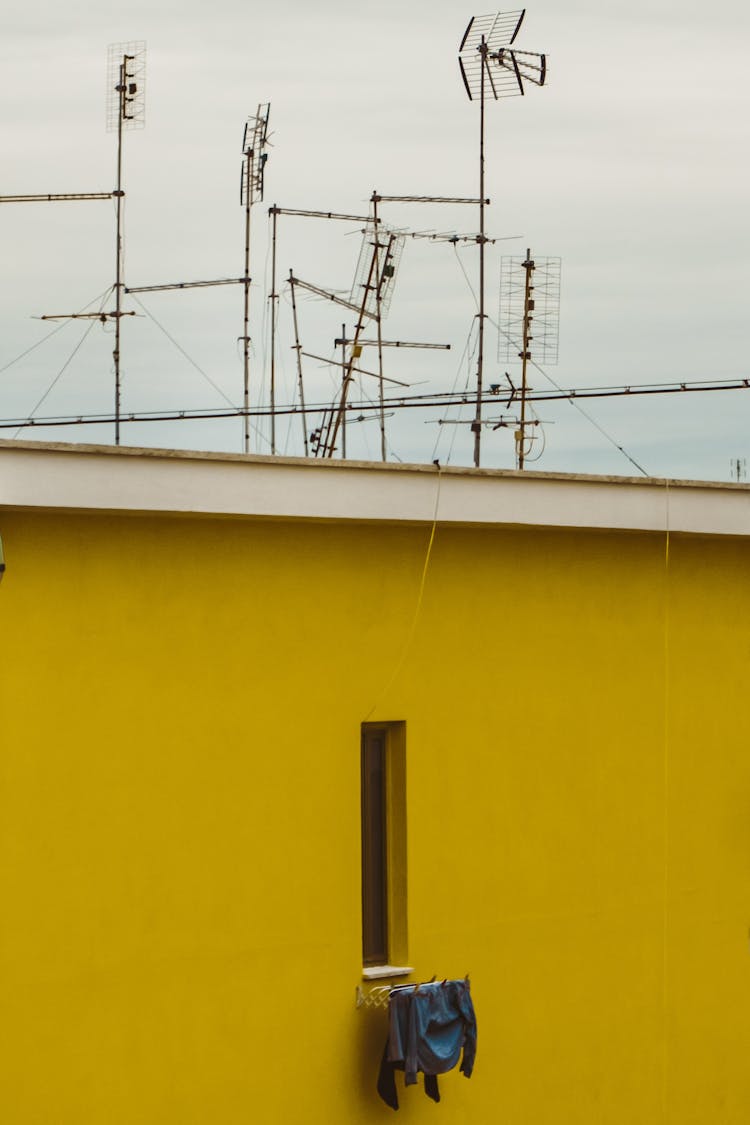 TV Antennas Above A Yellow Wall