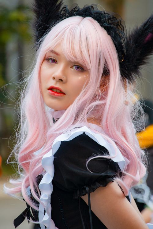 Free Stunning cosplay portrait featuring a young woman with pink hair and a black costume. Stock Photo