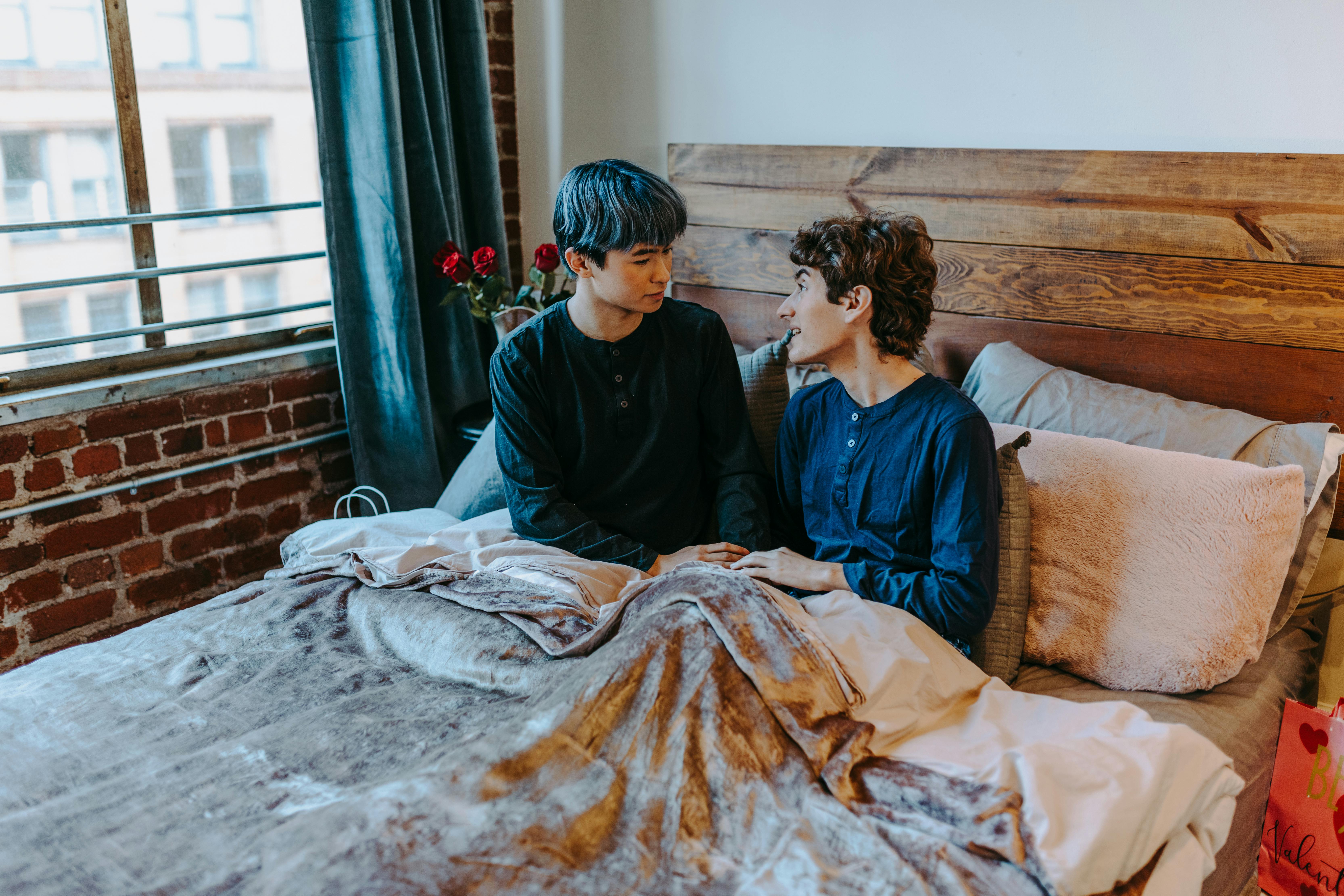 2 women sitting on bed