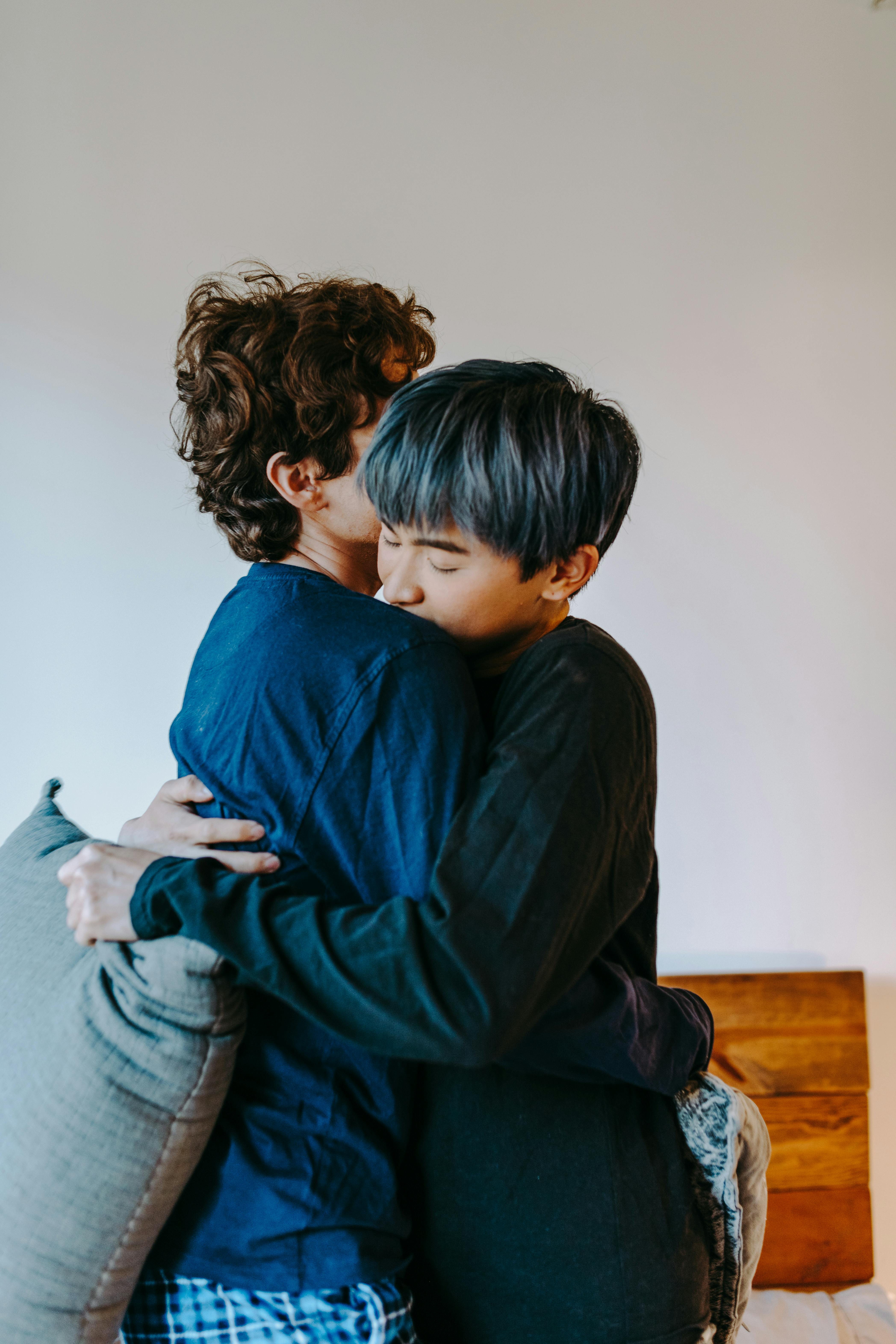 boy in blue long sleeve shirt and gray pants sitting on brown wooden chair