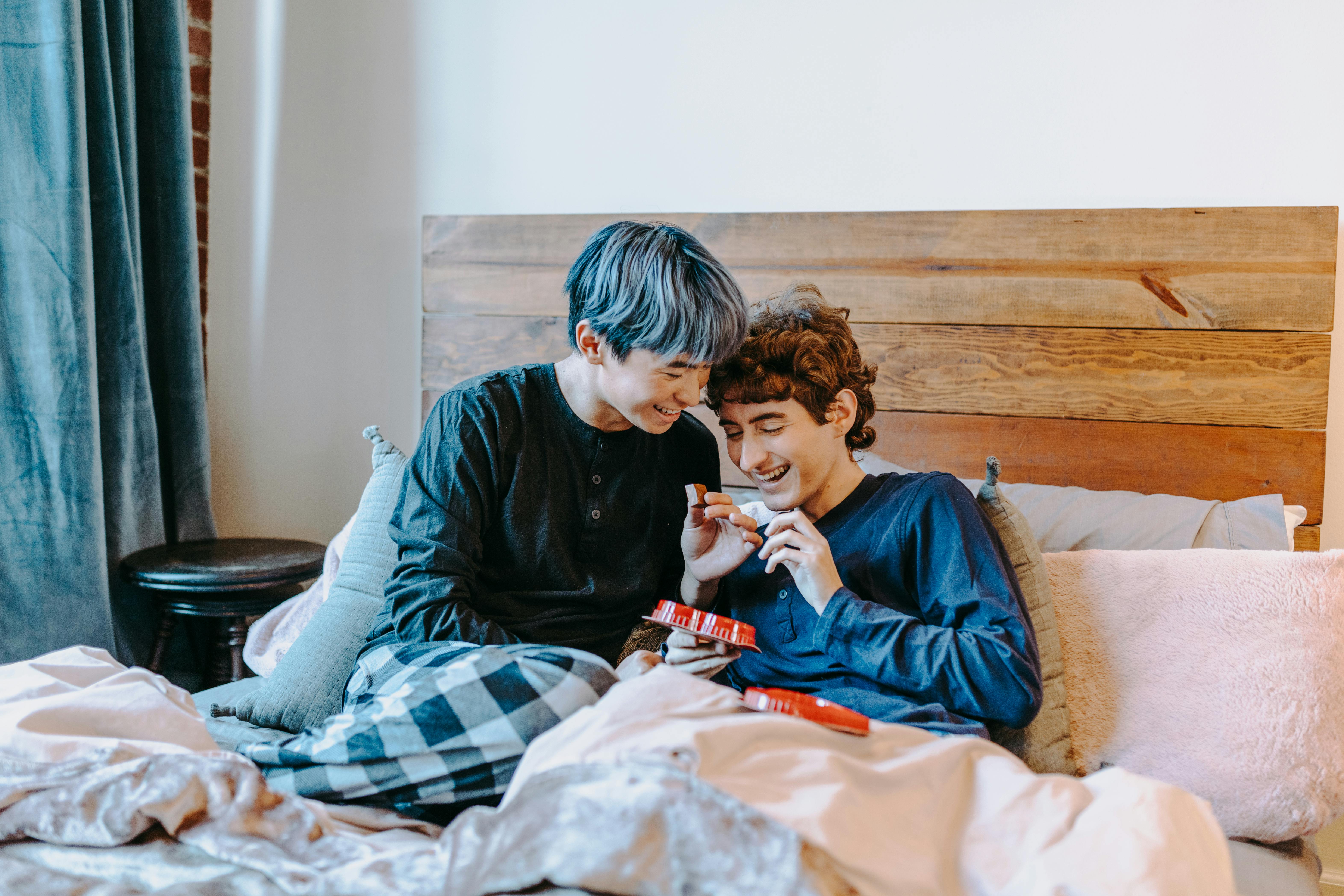 boy in black long sleeve shirt sitting on bed