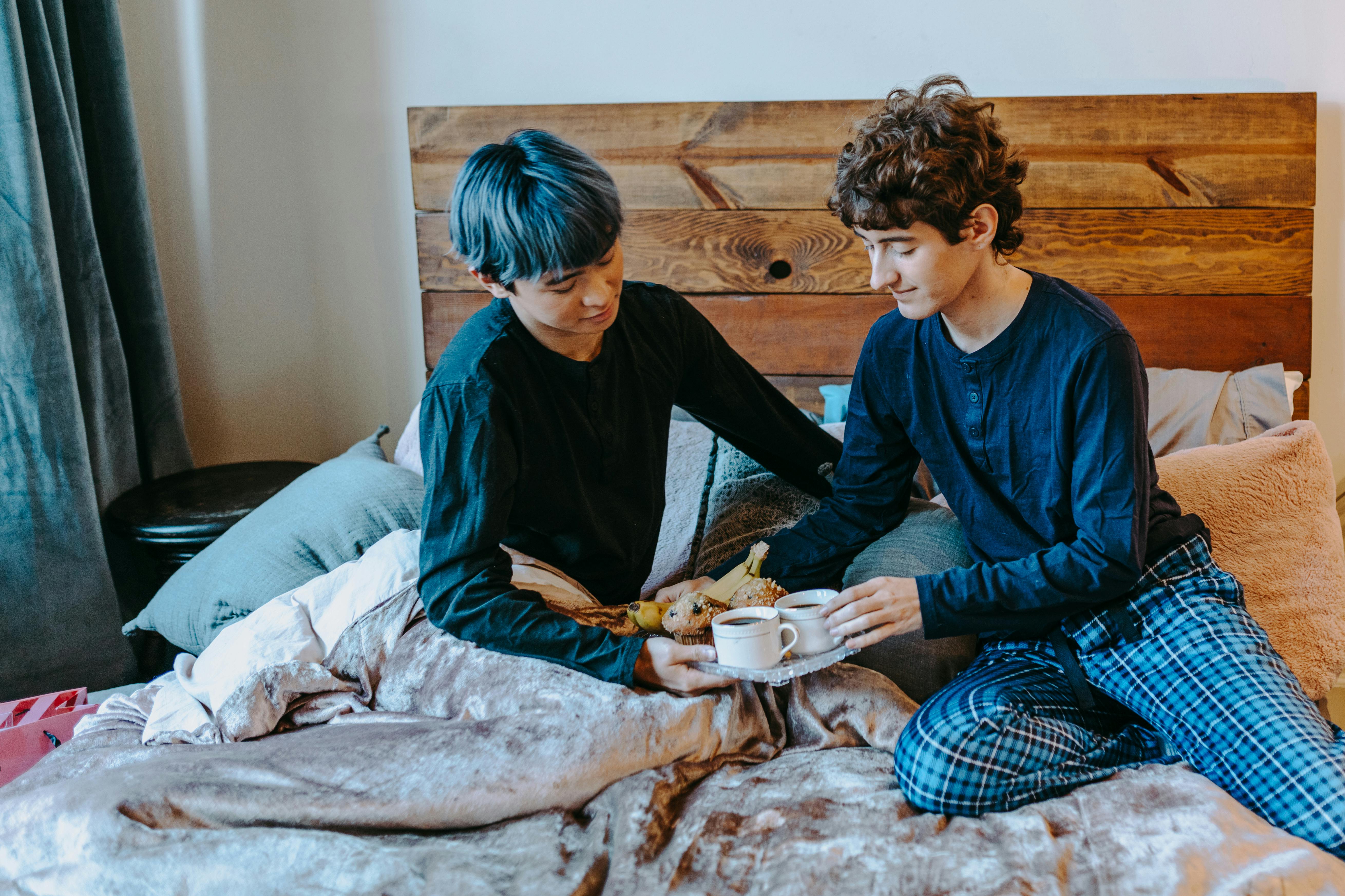 2 boys sitting on bed