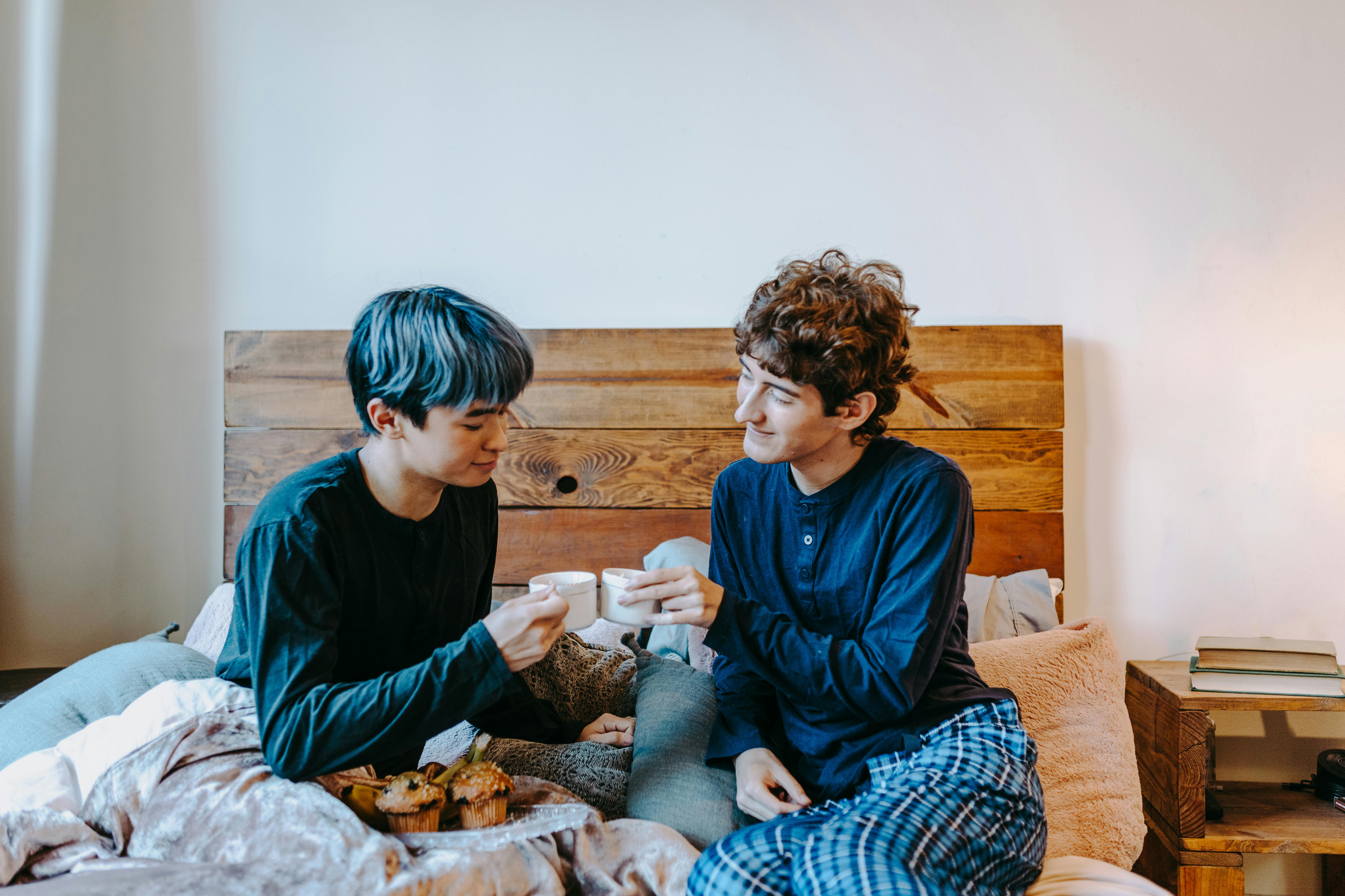 boy in blue long sleeve shirt sitting on bed