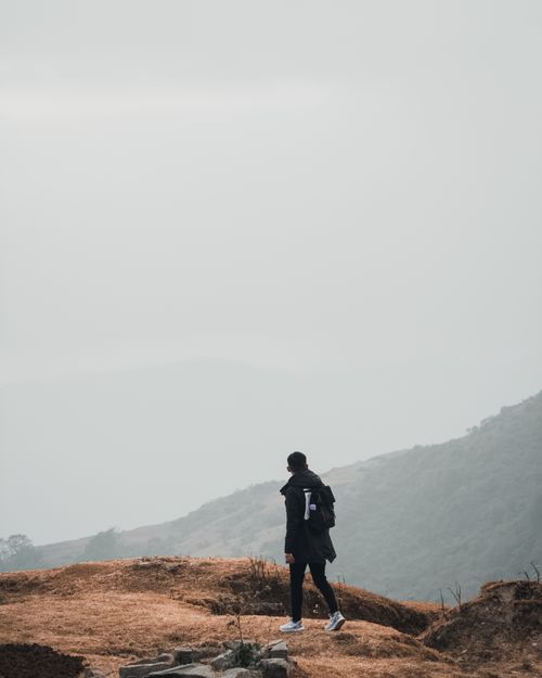 Free A solitary hiker stands amidst the serene misty hills of Nepal, embracing nature's tranquility. Stock Photo