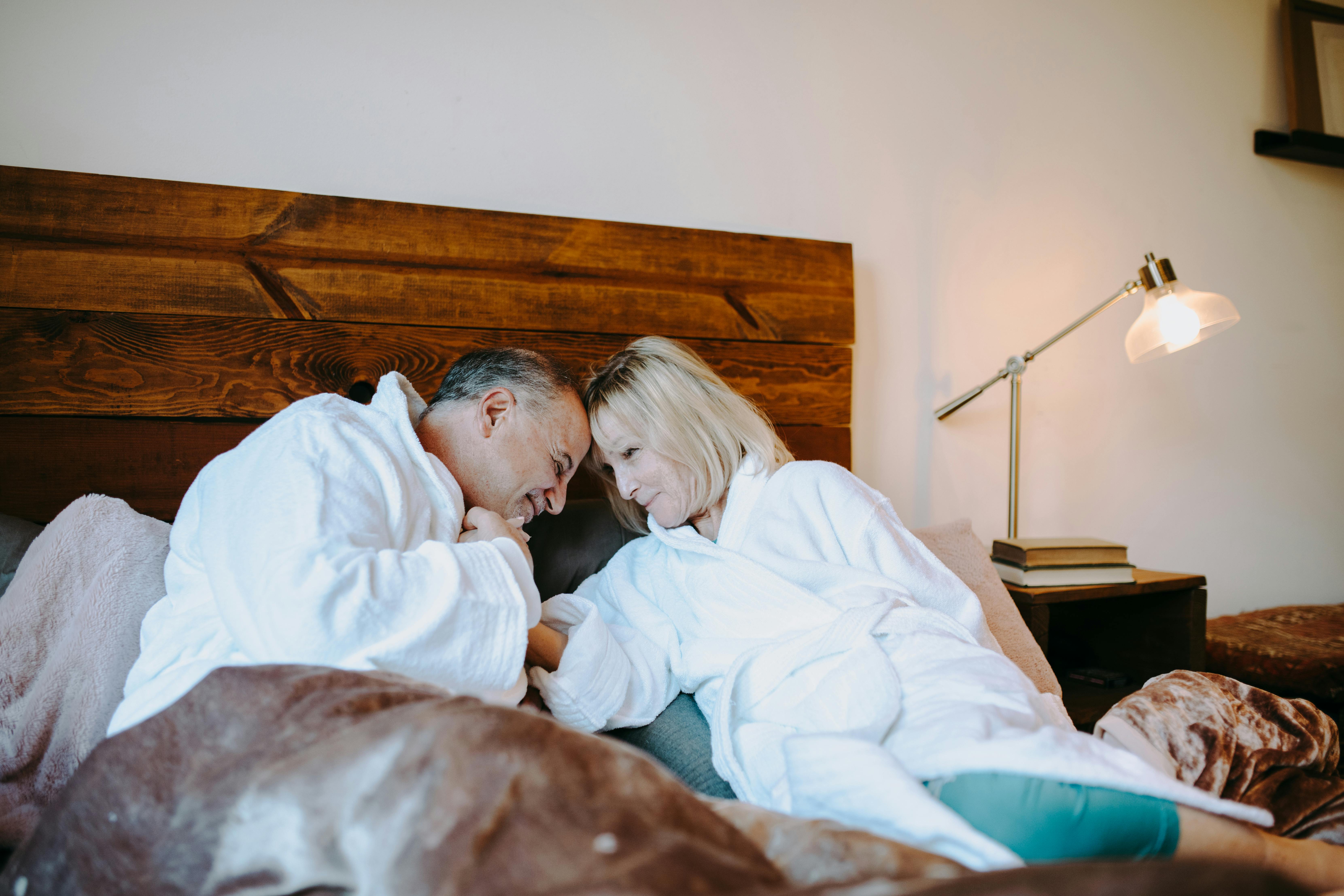 man in white robe lying on bed