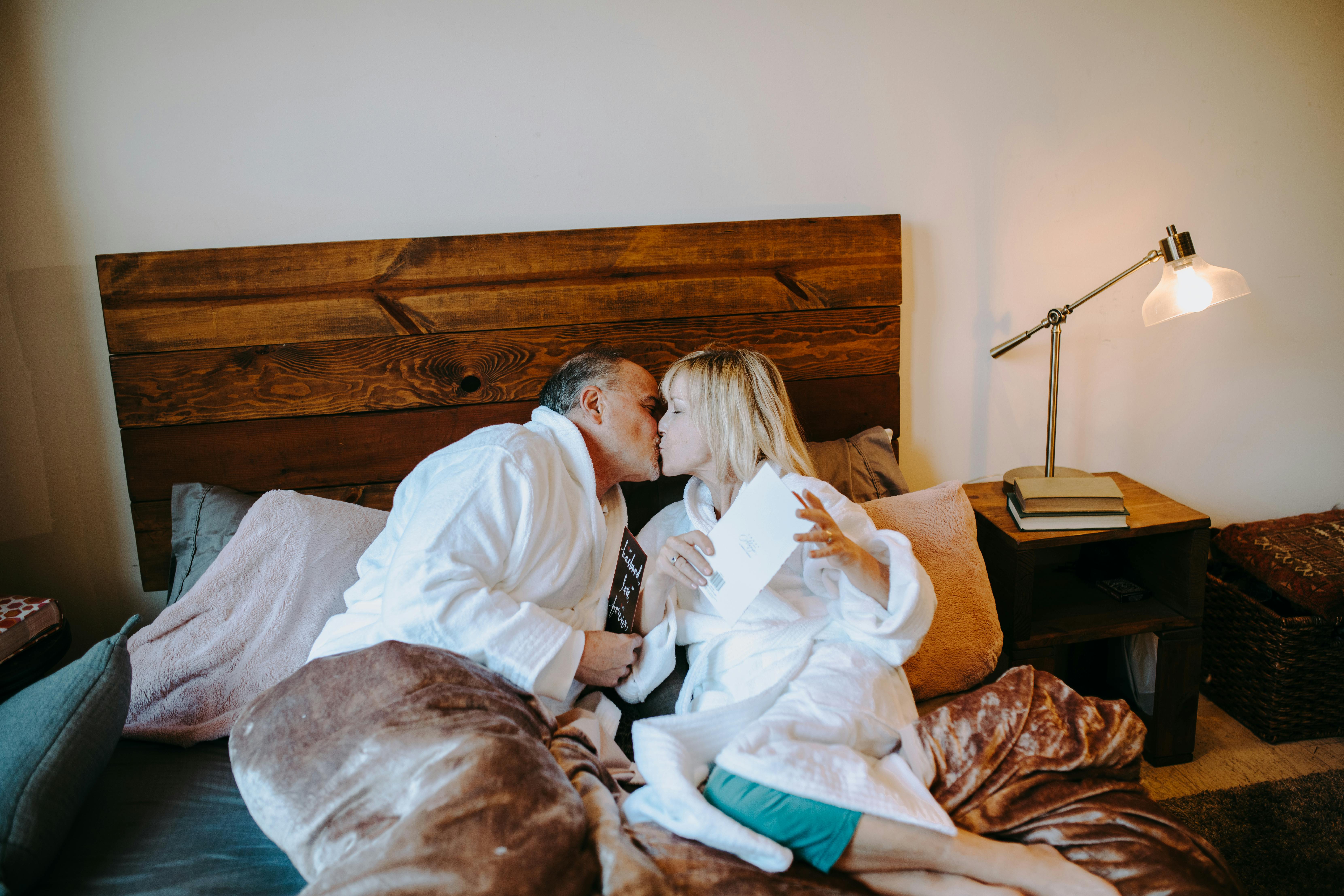 man in white robe lying on bed