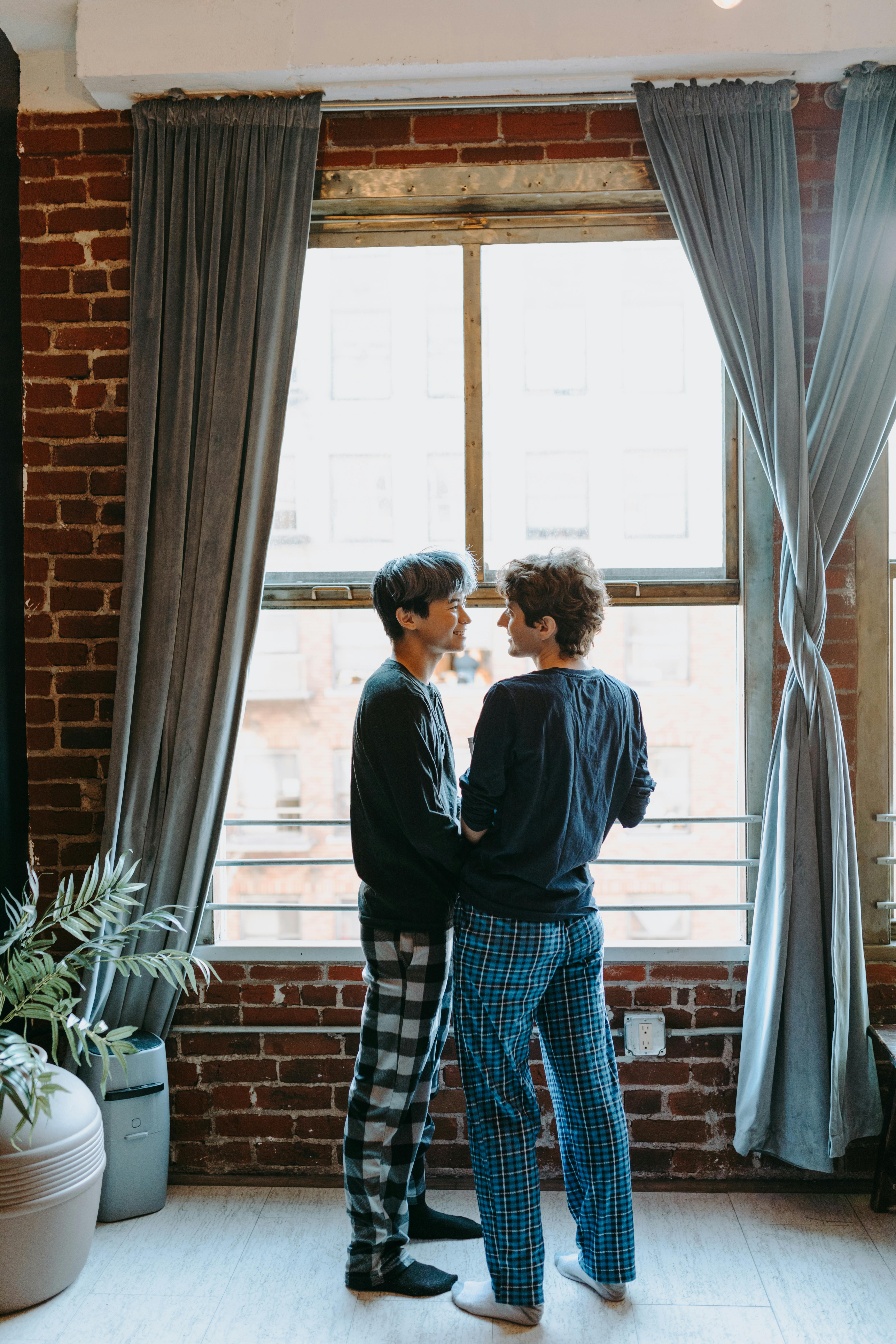 man and woman standing in front of window