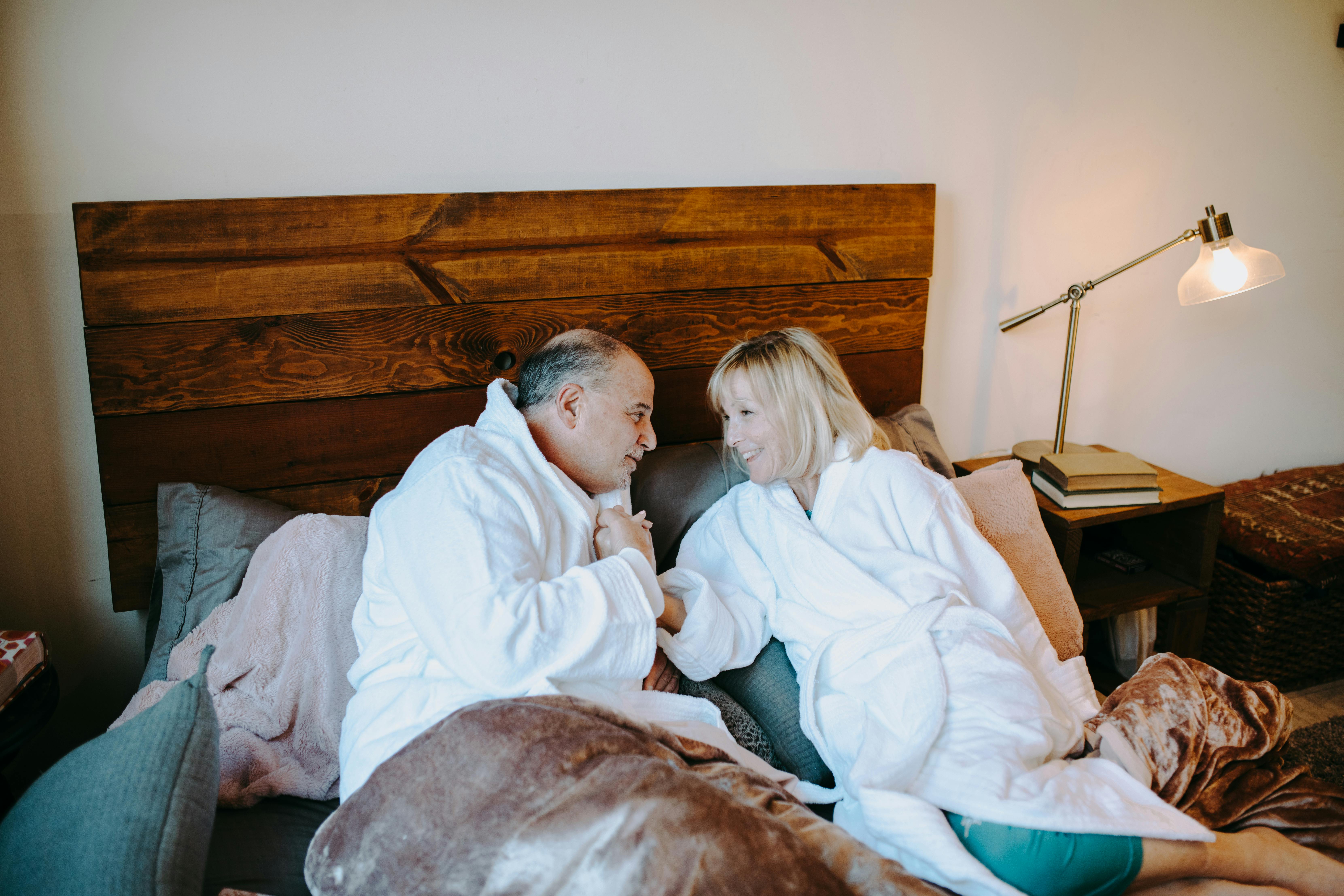 man in white dress shirt sitting beside woman in white robe