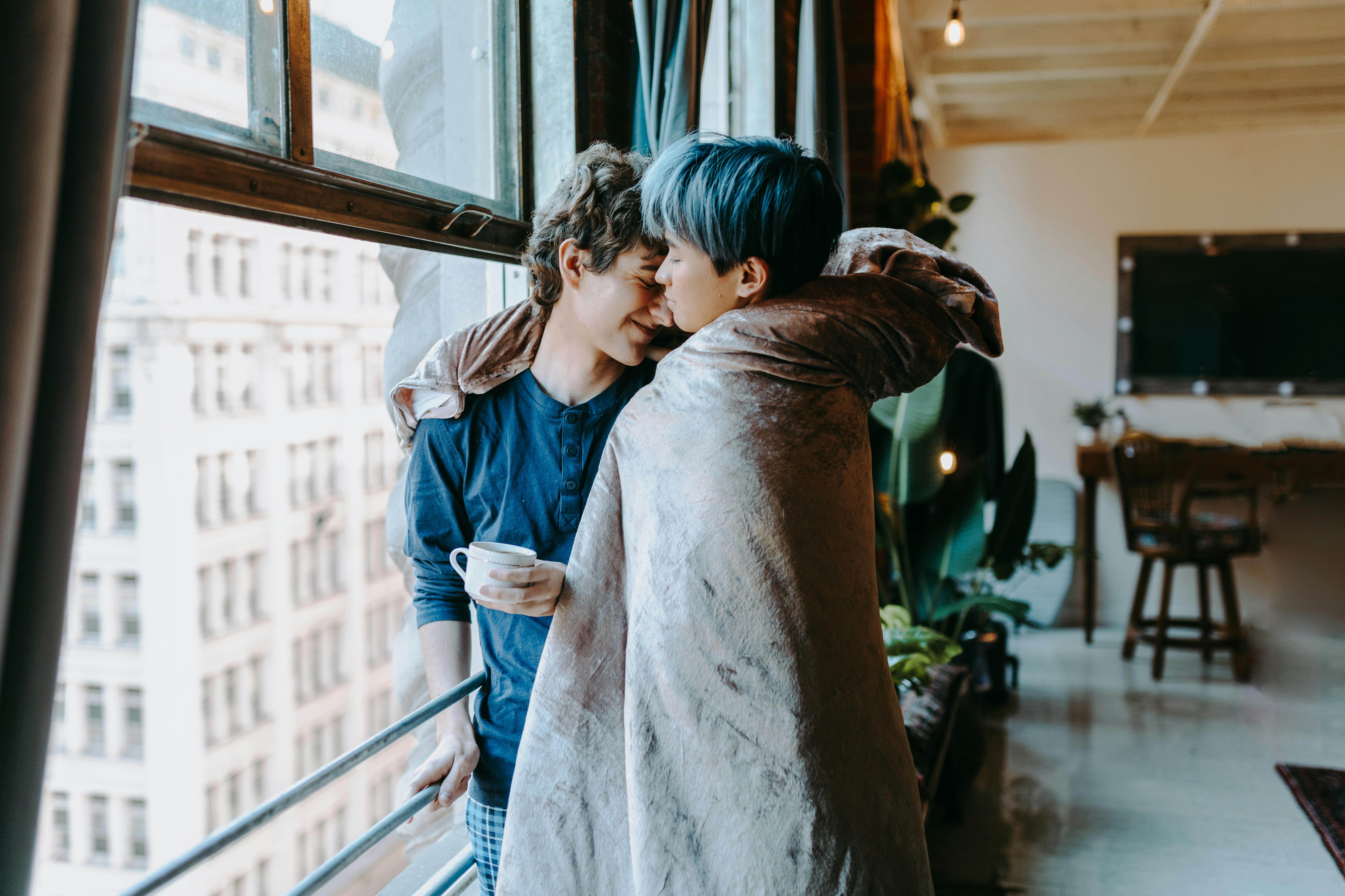 girl in blue denim jacket hugging girl in gray jacket