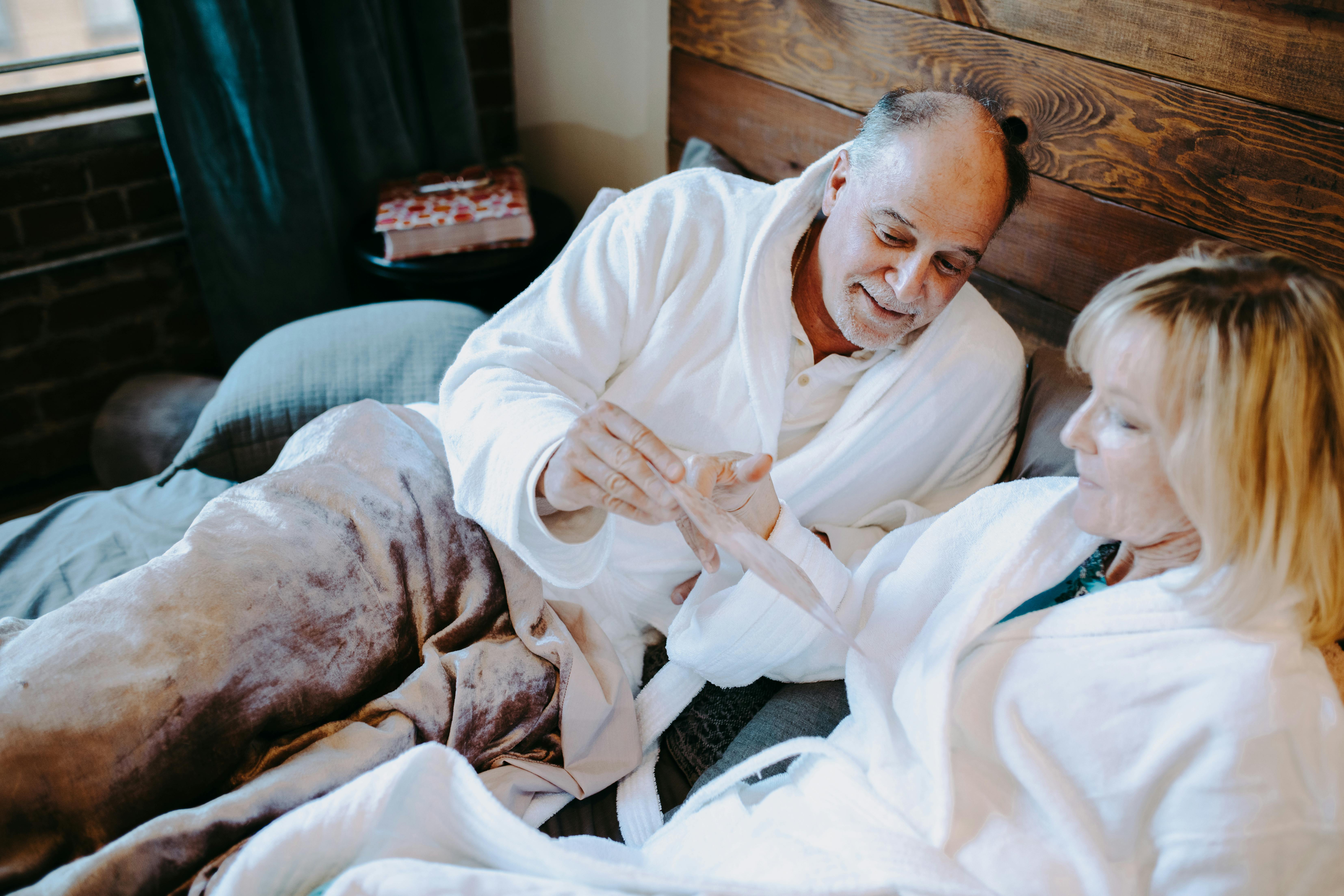 man in white robe lying on bed