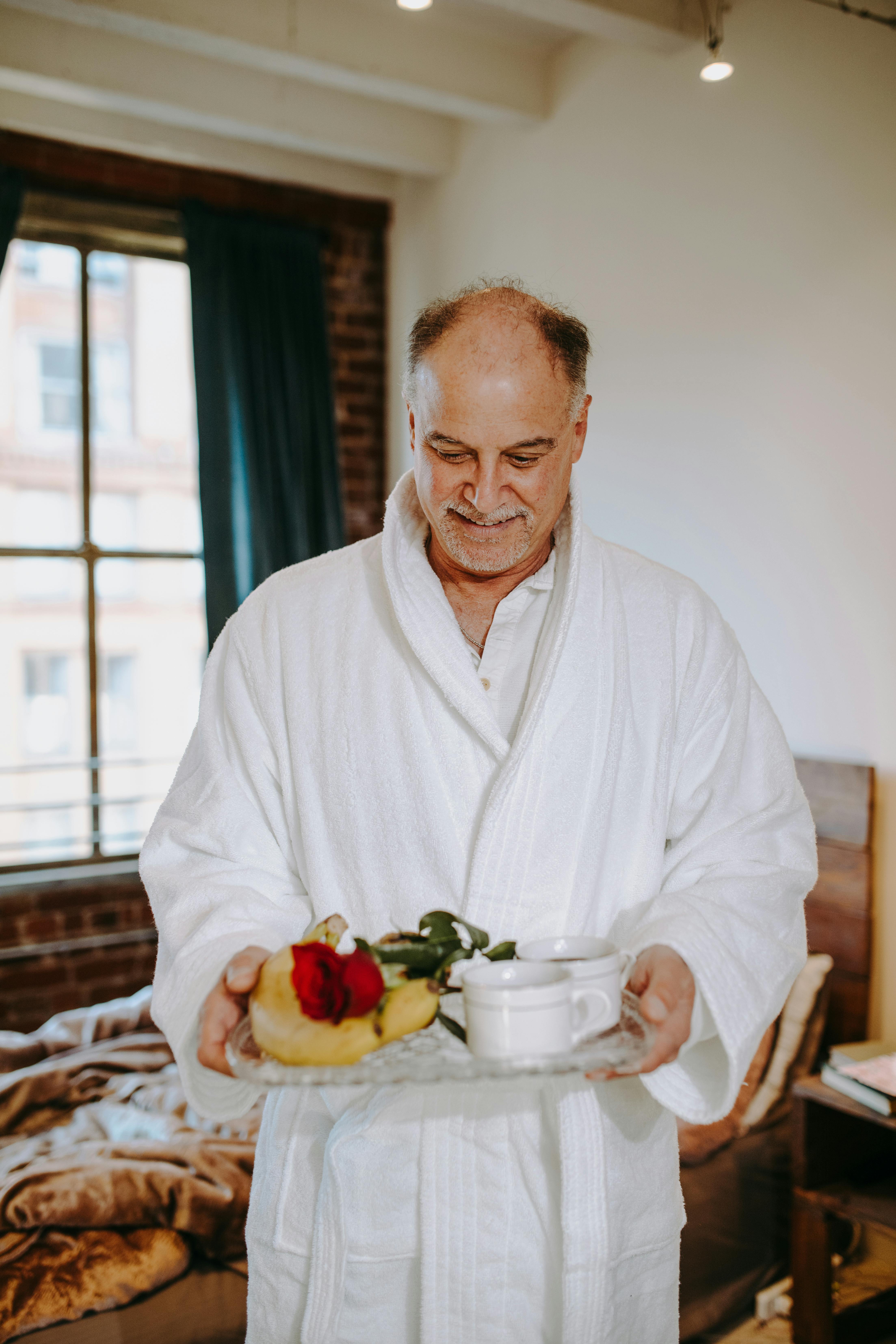 man in white dress shirt sitting on chair in front of table with fruits