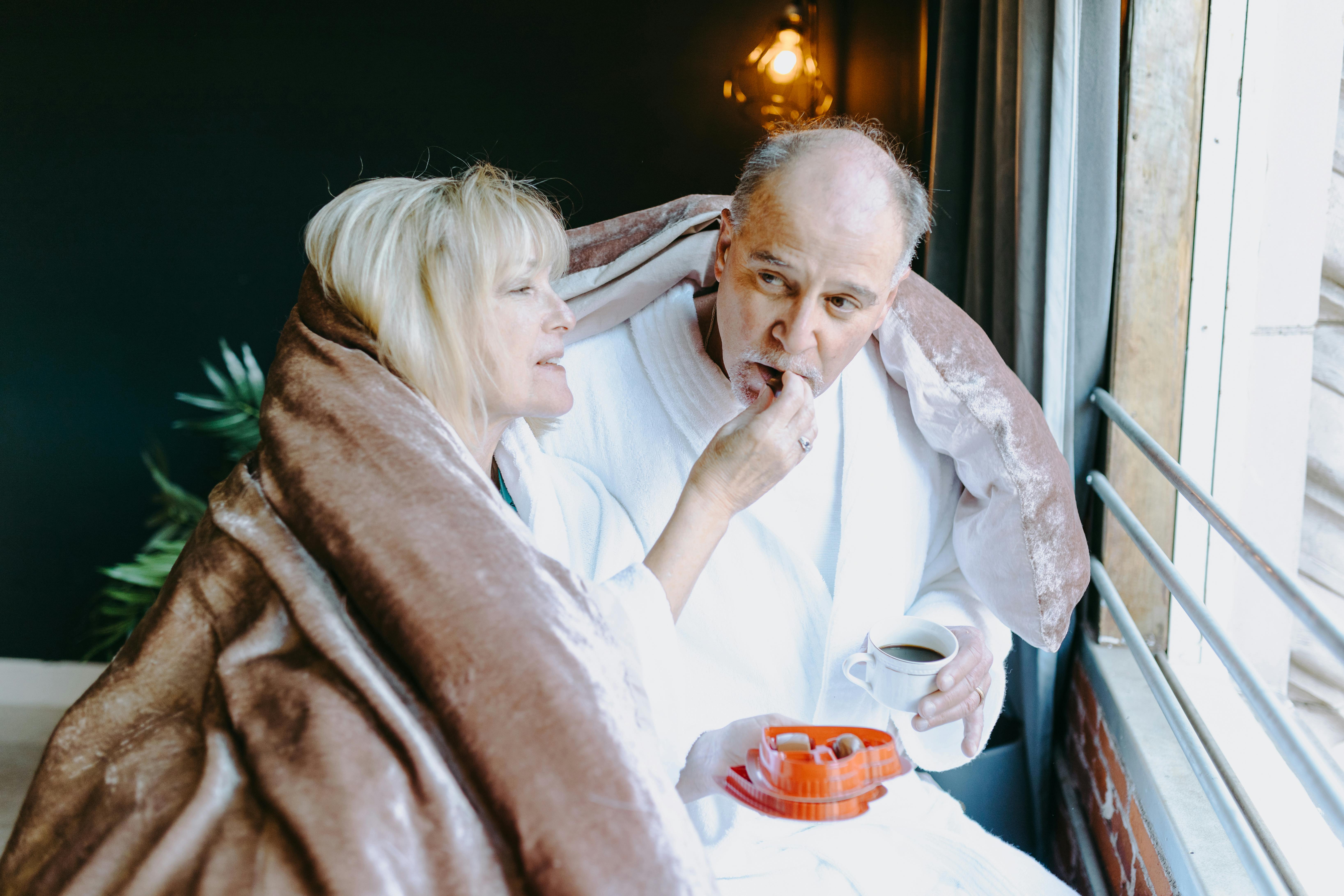 man in white polo shirt sitting beside woman in white shirt