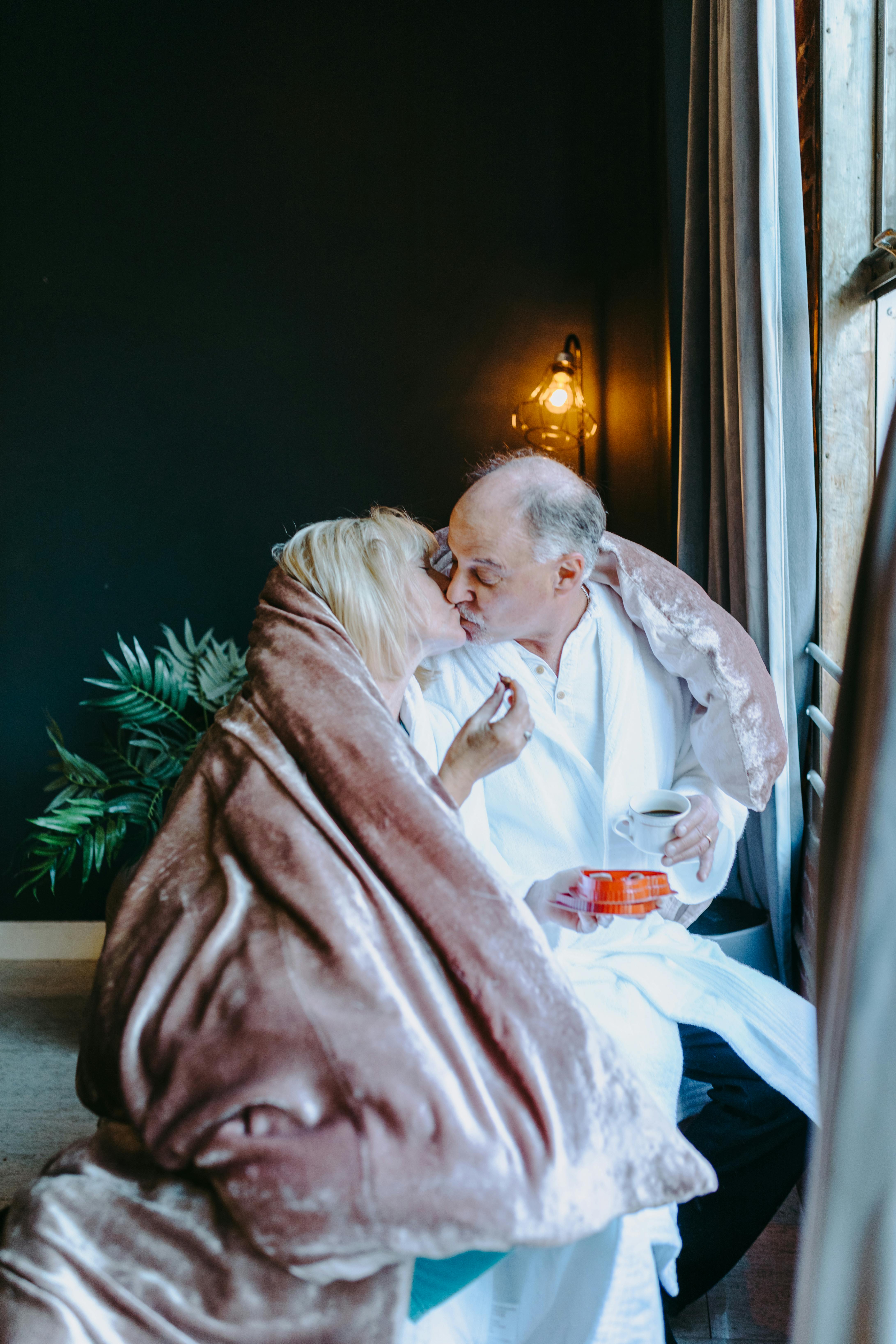 man and woman kissing on bed