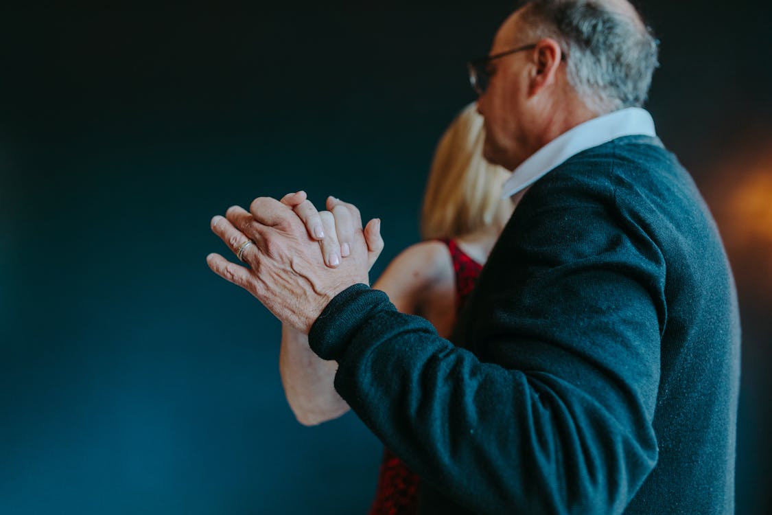 Photograph of an Elderly Couple Dancing while Holding Hands
