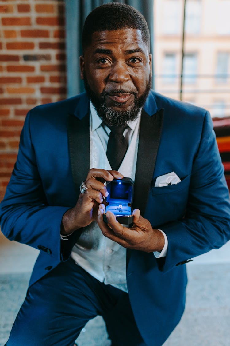 Photograph Of A Man In A Blue Suit Proposing 