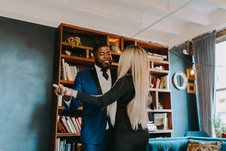 Photo Of A Man In A Blue Suit Dancing With A Woman In A Black Dress