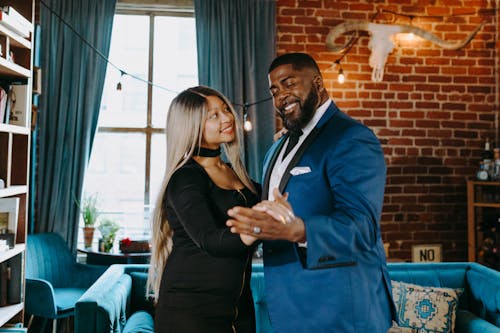 A Couple Smiling while Dancing Together