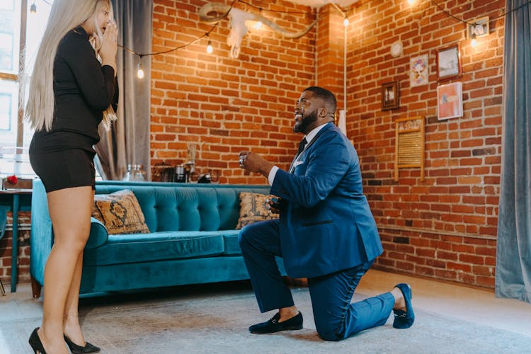 Photograph Of A Man In A Blue Suit Proposing To A Woman