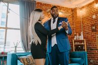 Man in Black Suit Standing Beside Woman in Blue Dress