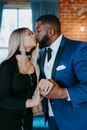 Man in Blue Suit Jacket Kissing Woman in Black Spaghetti Strap Top