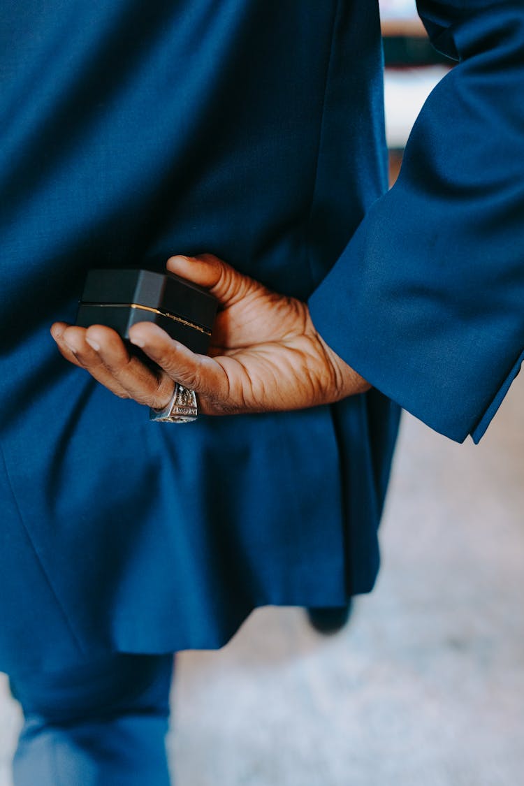 Photograph Of A Person's Hand Holding A Ring Box