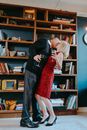 Man in Black Long Sleeve Shirt Kissing Woman in Red Dress