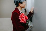 Man in Red Suit Holding Red Rose