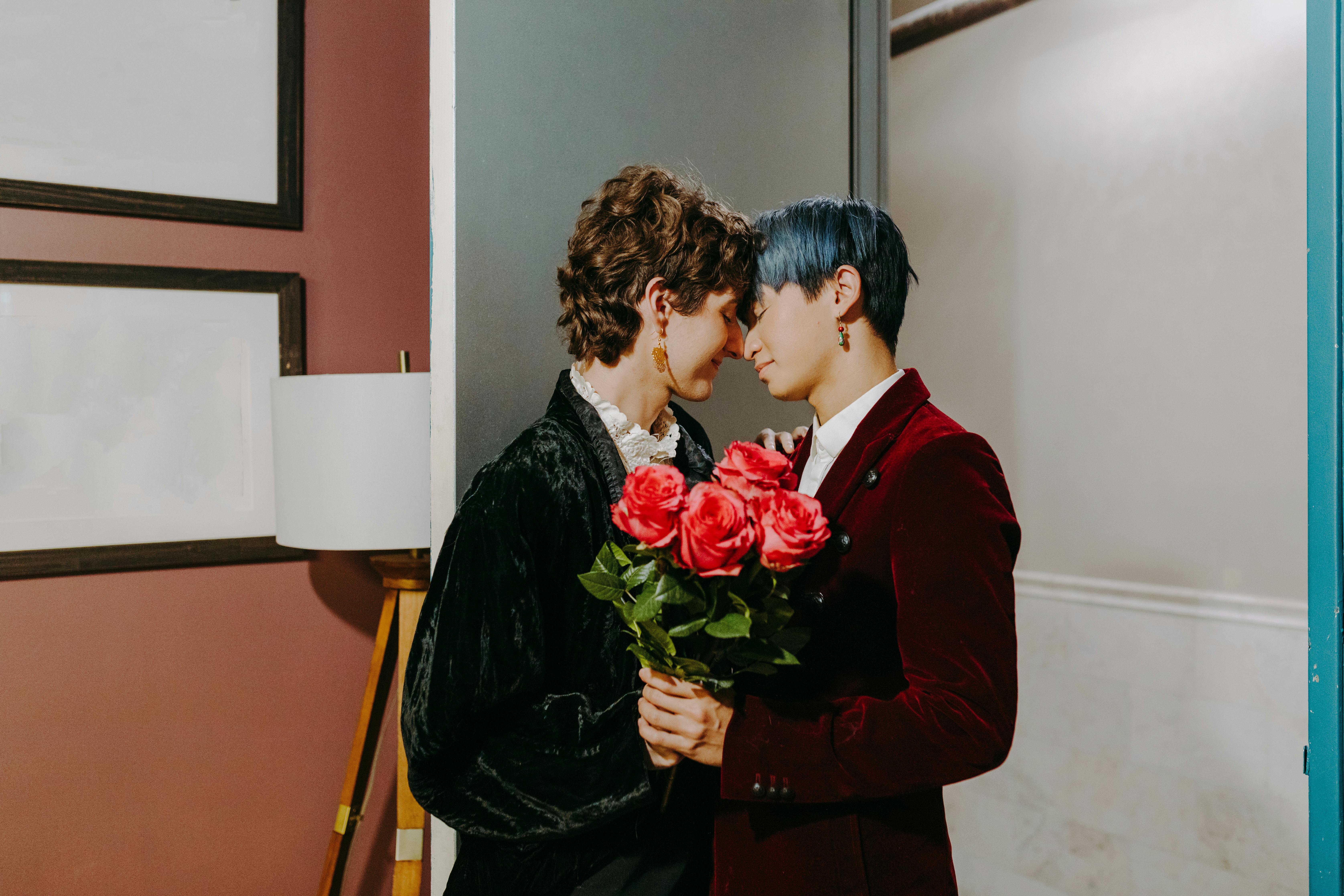 a couple holding a flowers while kissing