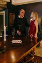 Man in Black Suit Jacket Sitting Beside Woman in Red Sleeveless Dress