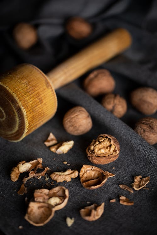 Free Close-Up Photo of Walnuts Near a Wooden Nut Cracker Stock Photo