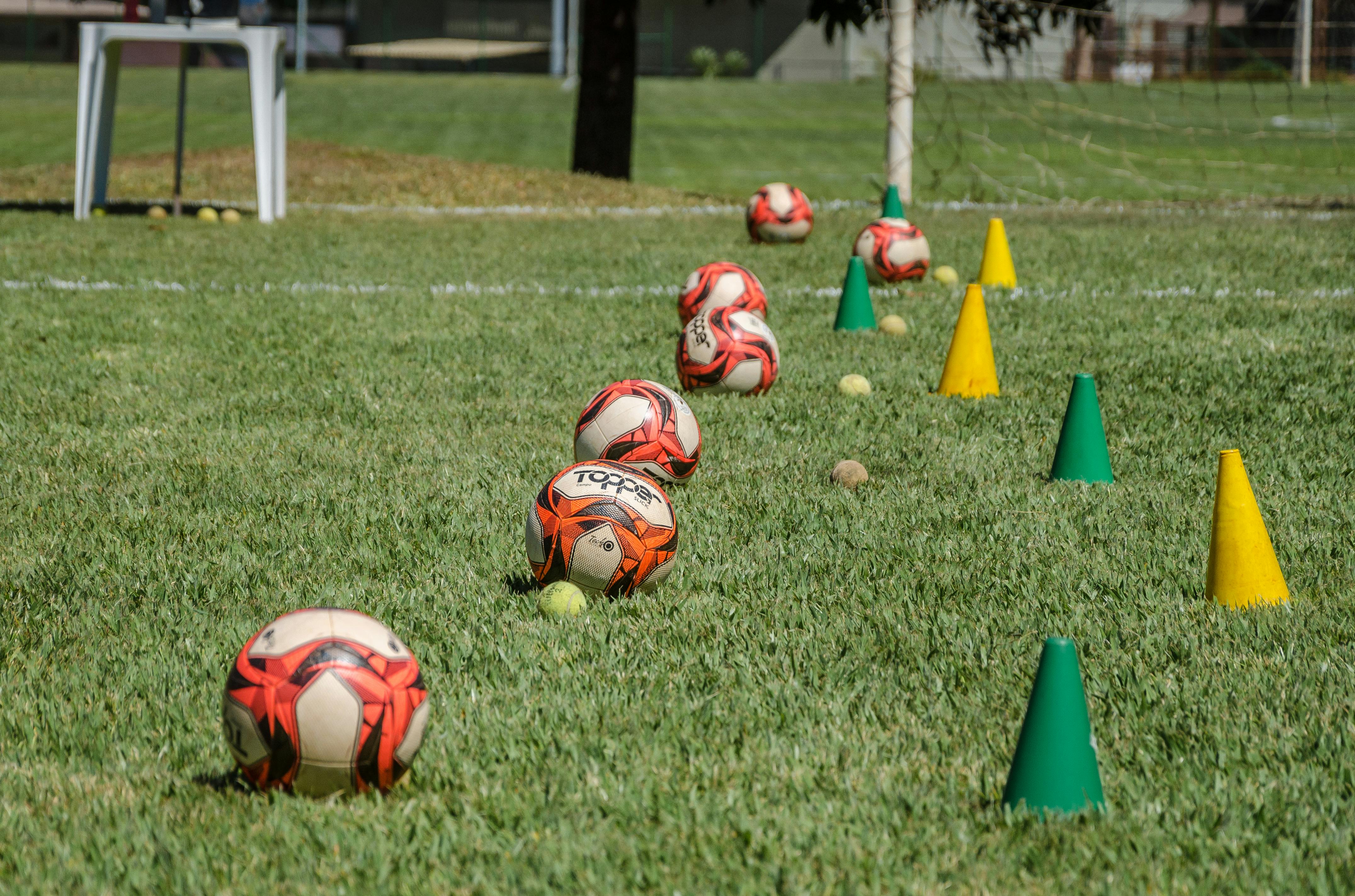 photograph of soccer balls near training cones