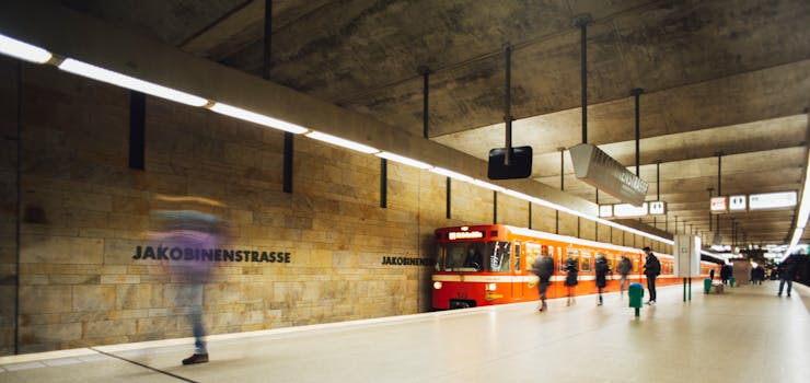 Long exposure of commuters and subway at Jakobinenstrasse station, showcasing urban transportation.