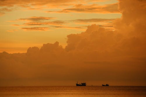 Silhouette of Boats on Sea at Sunset