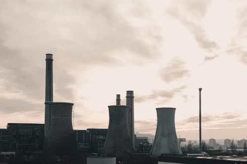 Free Wide-angle view of an industrial power plant with prominent cooling towers against a cloudy sky. Stock Photo